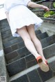 A woman in a white dress is walking up some steps.